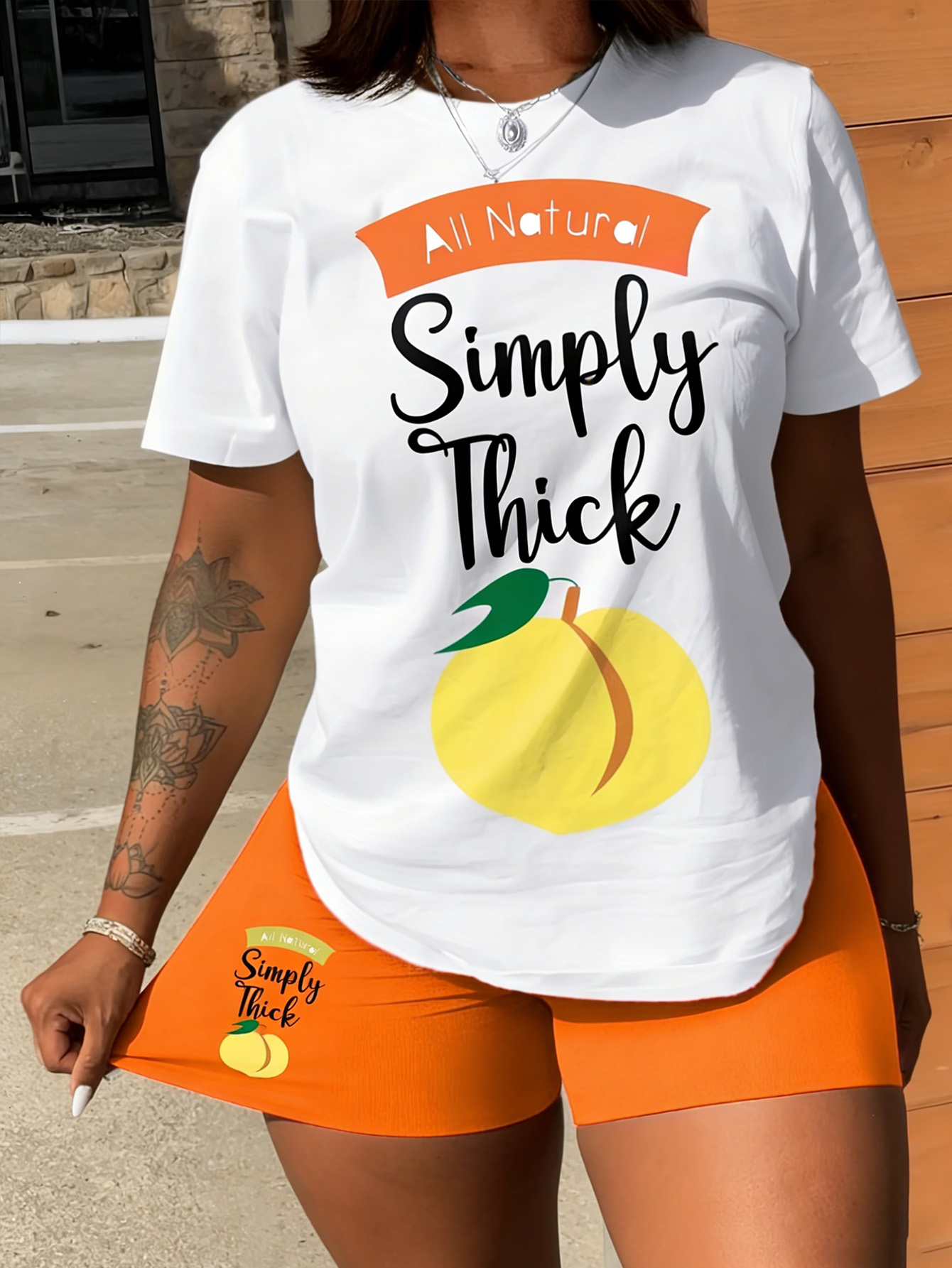 「All Natural Simply Thick」ロゴとフルーツ柄のプリントが施された、ラウンドネックが特徴の女性用のファッショナブルなカジュアルプラスサイズセットです。