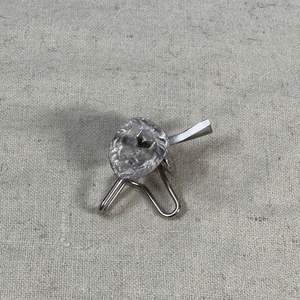 These silver lion-head pins or brooches are decorative accessories often used to adorn formal attire, such as on shako badges.