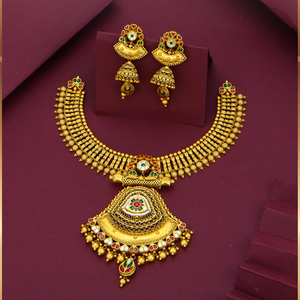 Traditional gold necklaces with antique pendant designs, paired with earrings featuring colored gemstones—luxury bridal jewelry for women